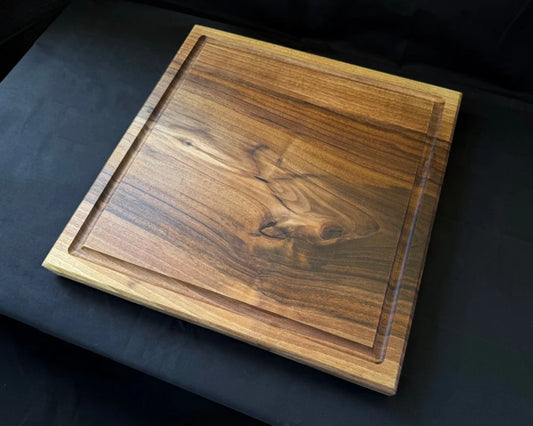Liegendes Nussbaum-Schneidebrett 50 × 50 × 5 cm mit Saftrille, quadratischer Arbeitsfläche und kräftiger natürlicher Maserung