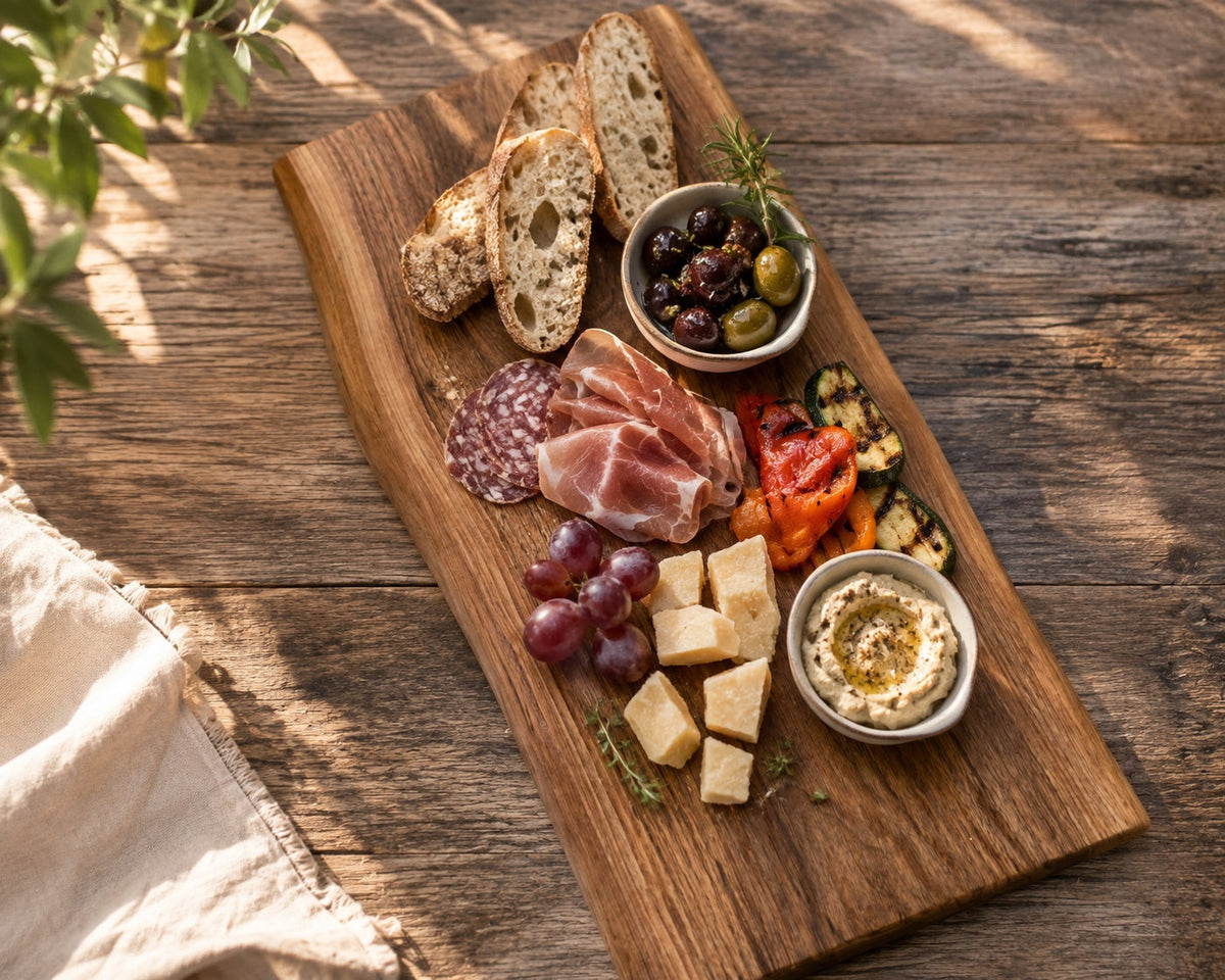 Mediterranes Sommerboard mit Burrata, gegrilltem Pfirsich, Prosciutto, Focaccia und Oliven auf massivem Holzbrett
