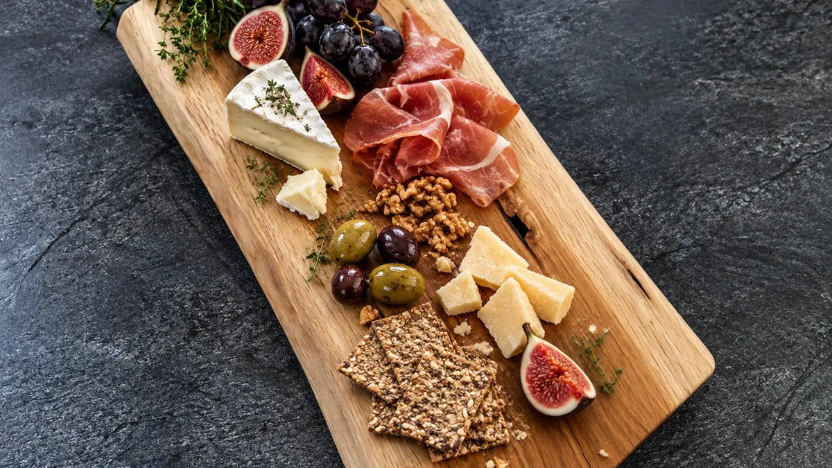 Charcuterie Board mit Käse, Feigen, Trauben und Aufschnitt auf einem Holzbrett