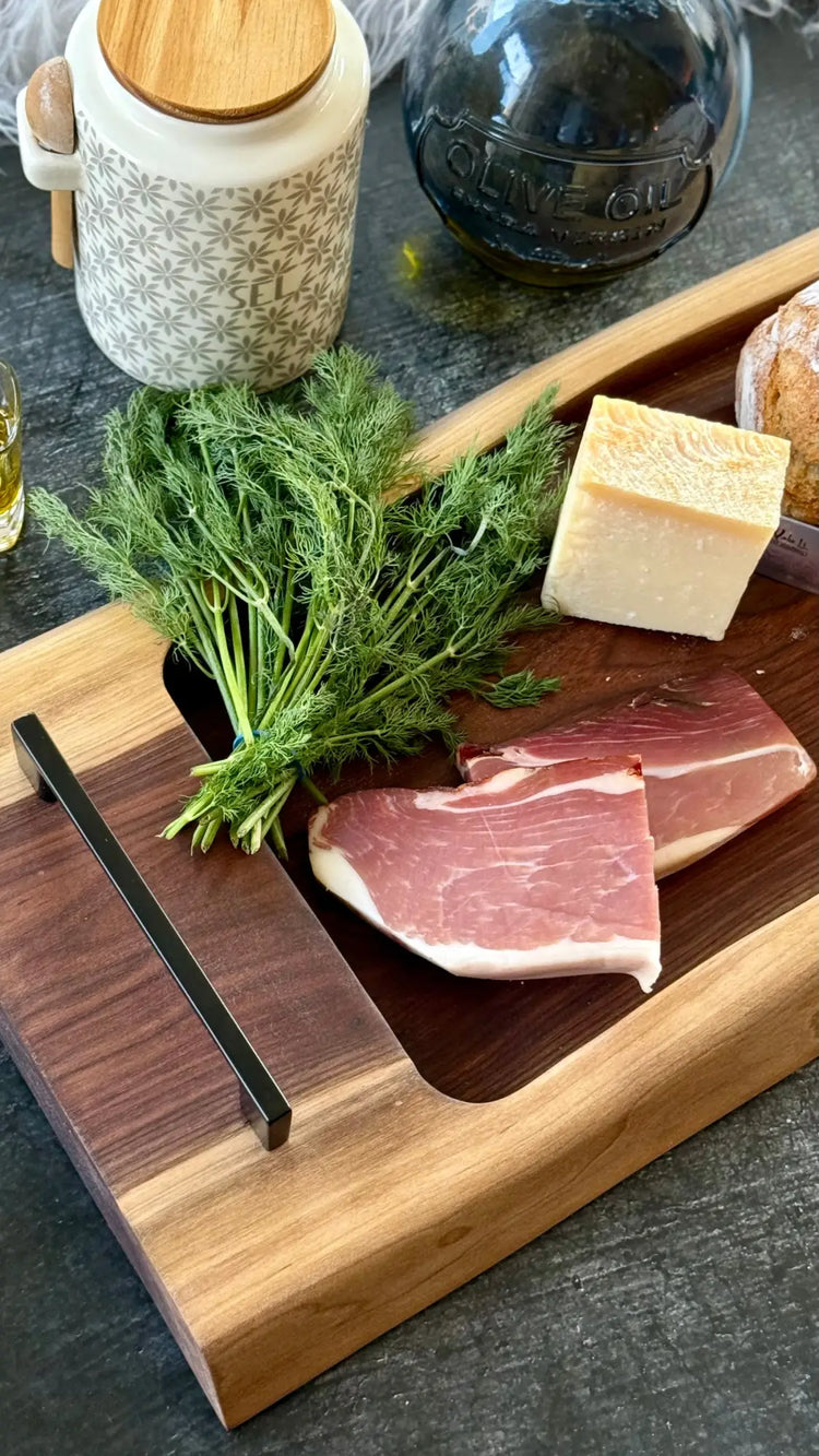 Schneidebrett aus Holz mit rohem Fleisch, frischem Dill und Butter darauf.