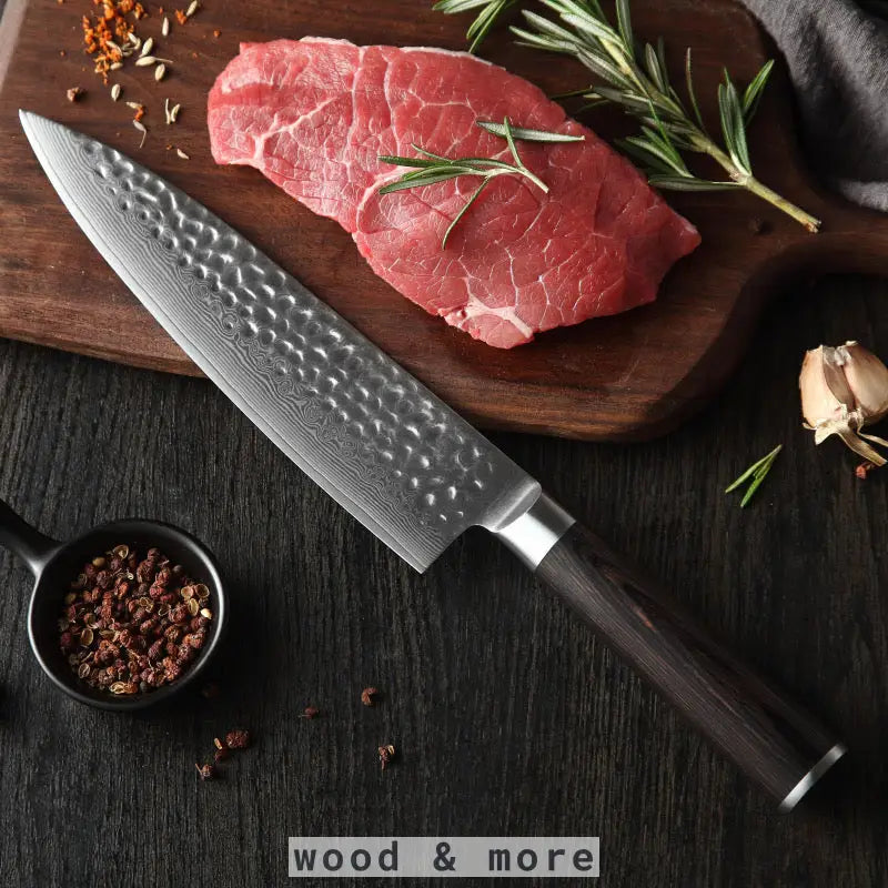 Damast Chefmesser mit Rosenholzgriff auf Holzbrett mit Steak und Gewürzen