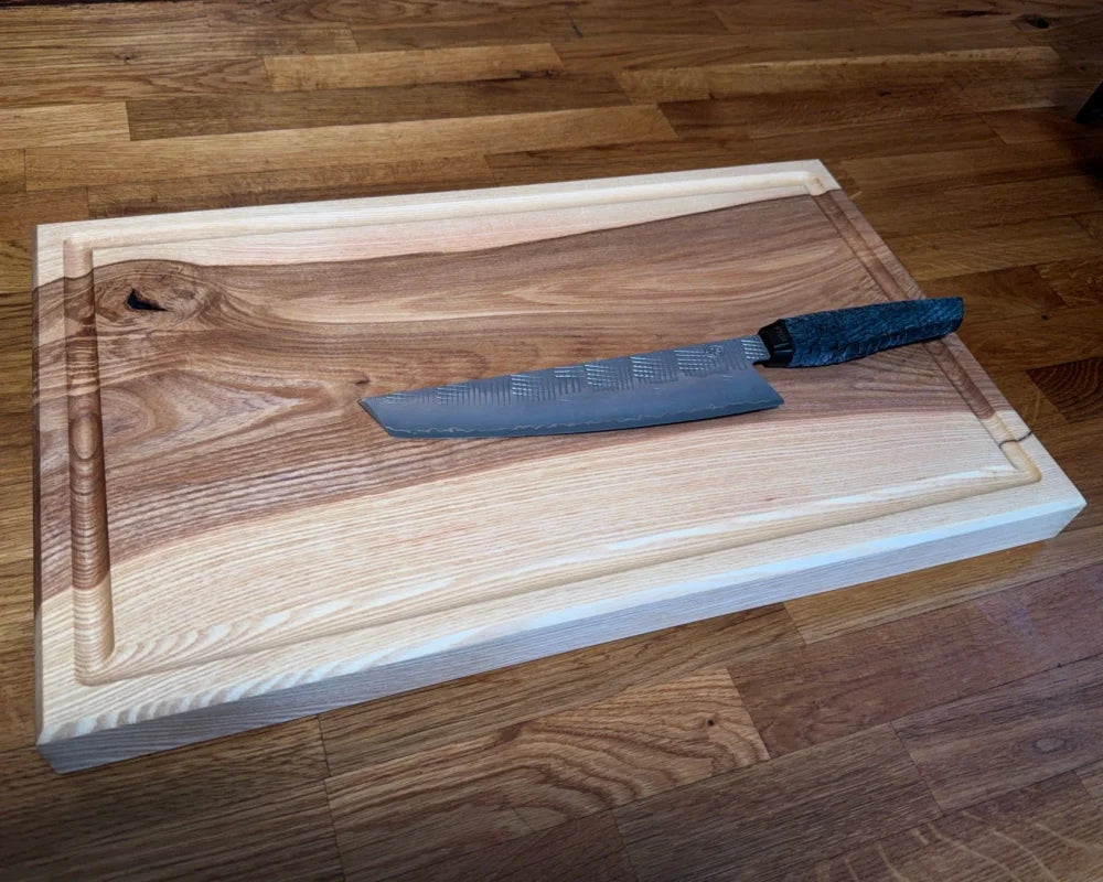 Chefbrett Esche 50×30×4 in Top-Ansicht mit Messer auf der Rillenseite
