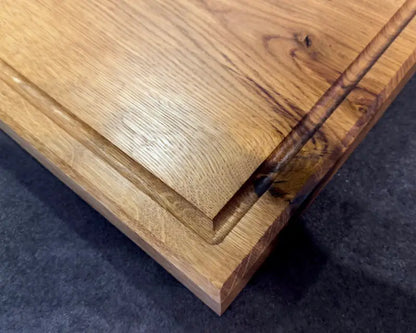 Nahaufnahme der Holzmaserung eines massiven Schneidebretts aus Eiche (30x30 cm), geölte Oberfläche und Saftrille sichtbar.