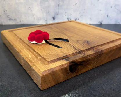 Profilansicht der Brettseite mit 4 cm dicke eines massiven Schneidebretts aus Eiche (30x30 cm), Profil und Saftrille sichtbar.