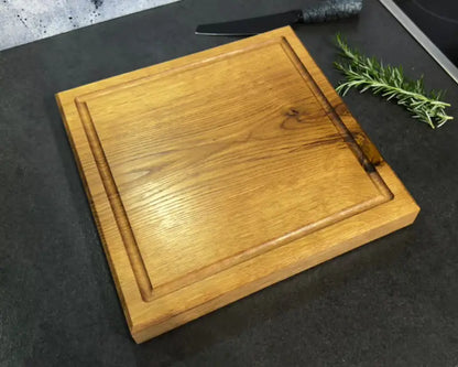 Geöltes Eichen-Schneidebrett 30x30 cm – edle Holzmaserung & natürliche Astzeichnung in Draufsicht auf dunkler Küchenfläche