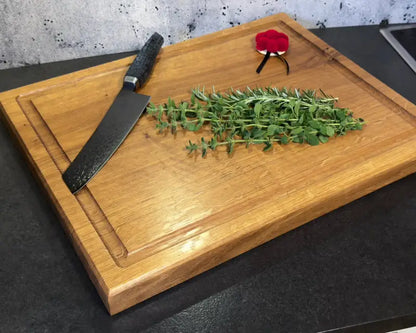 Grillmeister beim Tranchieren eines saftigen Steaks auf dem Holzbrett