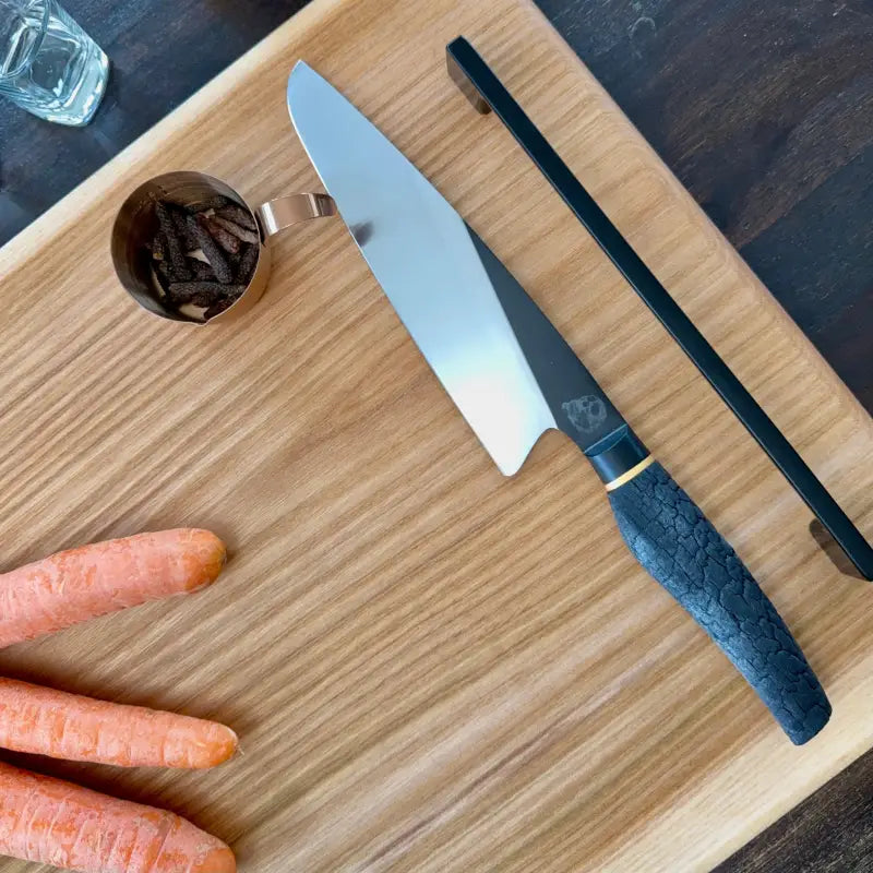 Chefmesser mit blauem Griff auf Ulmenholz Schneidebrett mit Metallgriffen