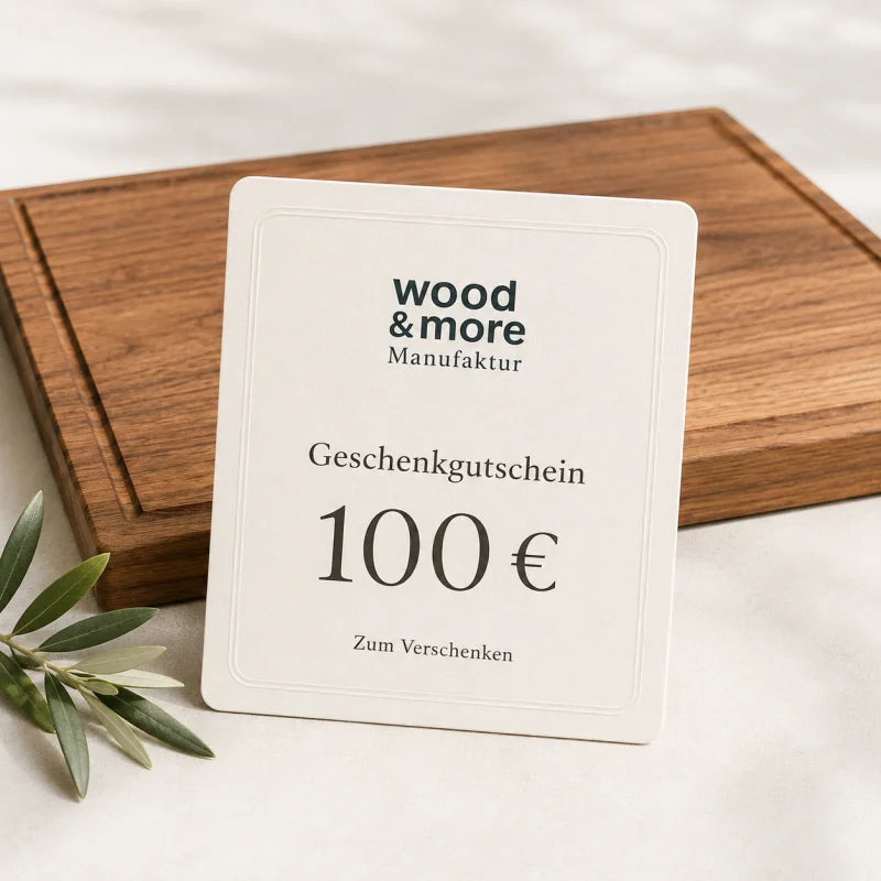 100 € Gutschein: wood & more Geschenkgutschein über 100 Euro mit massivem Holz-Schneidebrett auf hellem Hintergrund