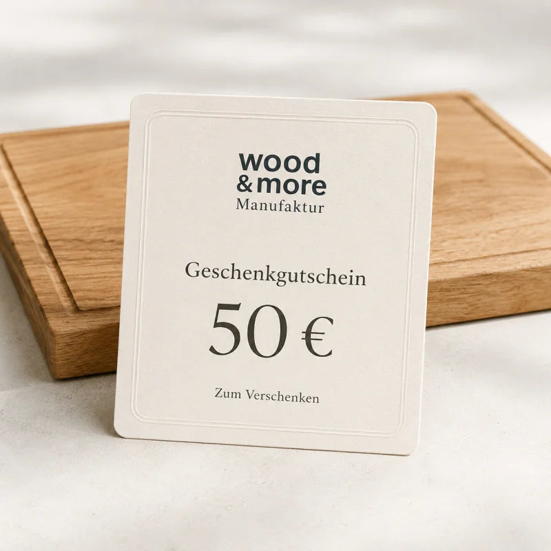 50 € Gutschein: wood & more Geschenkgutschein über 50 Euro vor einem hellen Eiche-Schneidebrett