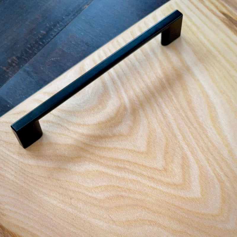Schwarzer Metallgriff an massivem Holzschneidebrett mit Saftrille in Wunschgröße