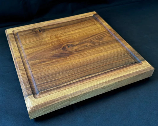 Liegendes Nussbaum-Schneidebrett 40 × 40 × 5 cm mit Saftrille, massiver Stärke und markanter natürlicher Maserung