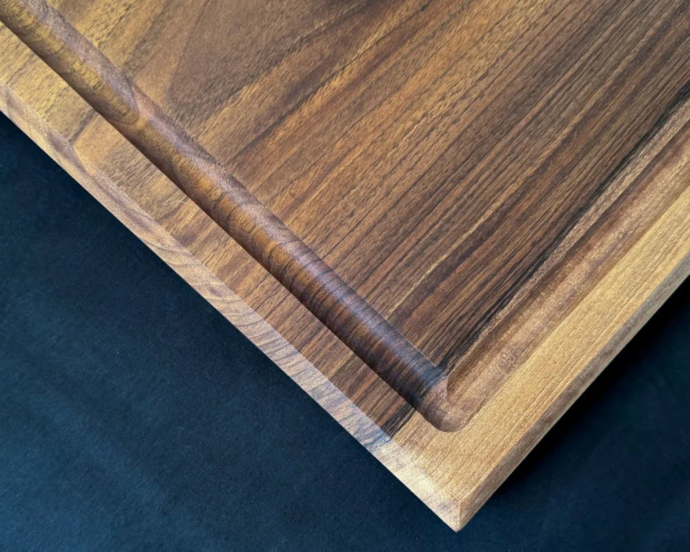 Detailansicht der Saftrille und ausdrucksstarken Maserung des massiven Nussbaum-Schneidebretts 40 × 40 × 5 cm