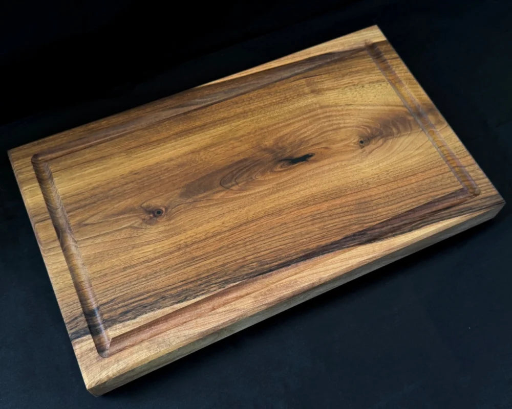 Liegendes Nussbaum-Schneidebrett 50 × 30 × 5 cm mit Saftrille, glatter Wendeseite und markanter Holzmaserung