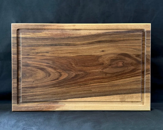 Großes massives Nussbaum-Schneidebrett 60 × 40 × 5 cm in frontaler Ansicht mit Saftrille und kräftiger Maserung