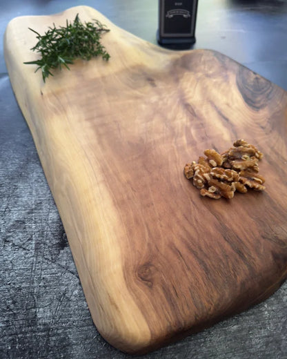 Großes Vollholzbrett aus Nussbaum mit heller Holzfläche und dunklem Astbereich