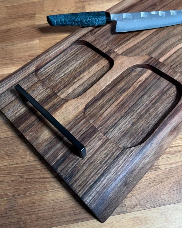 Schwarze Metallgriffe am Nussbaum-Board, ergonomischer Transport, Detail