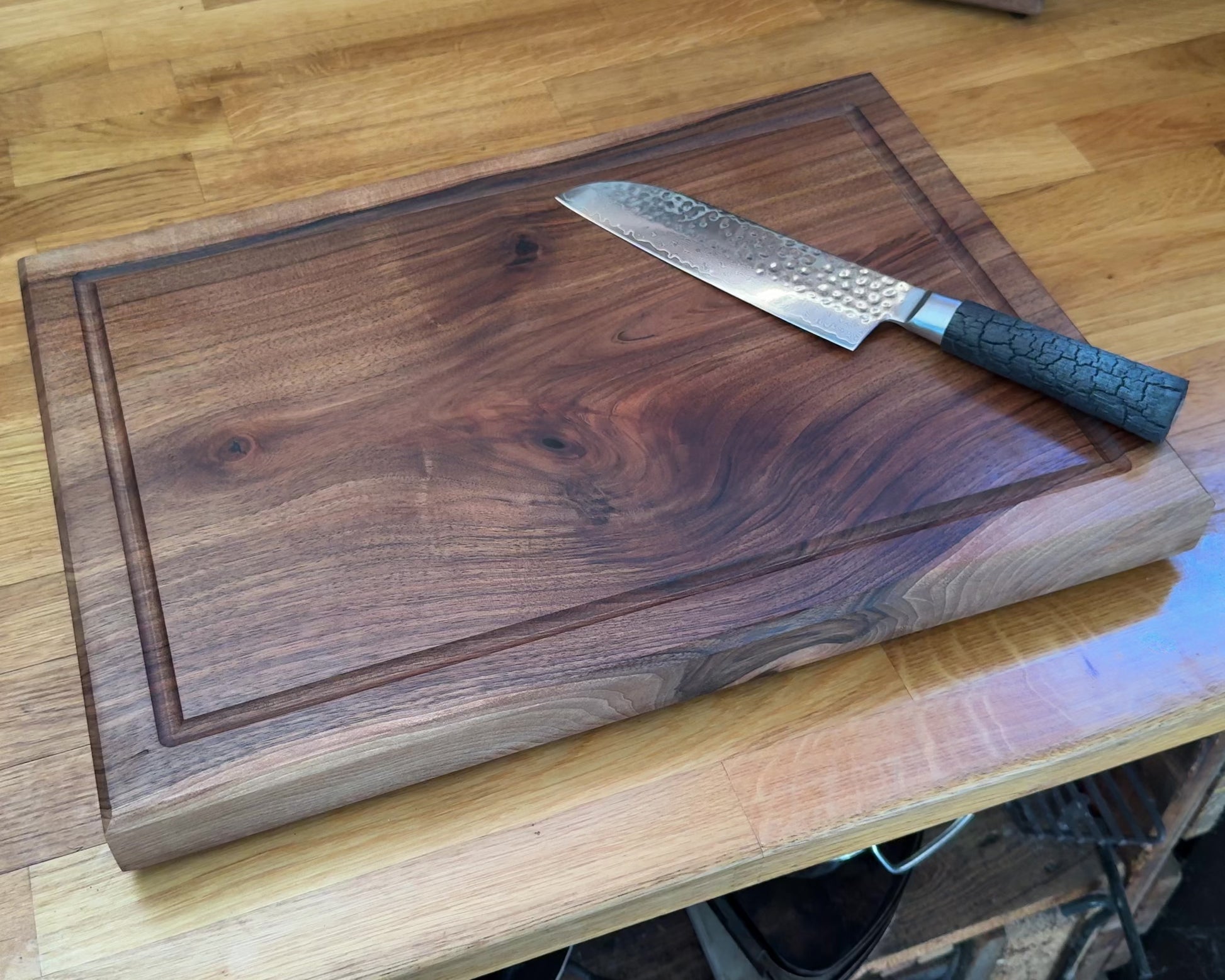 Video zeigt das Premium Chefbrett aus massivem Nussbaum mit Damastmesser – 4 cm stark, mit Saftrille. Detailzoom auf Maserung & Verarbeitung.