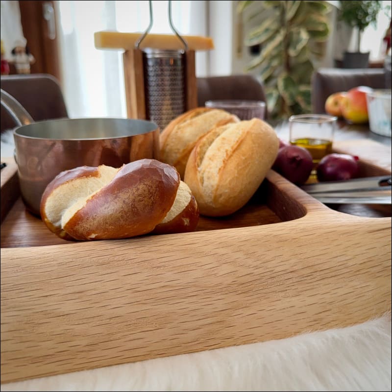 Frische Brötchen auf handgefertigtem Snackboard aus Ulmenholz mit Griffmulden