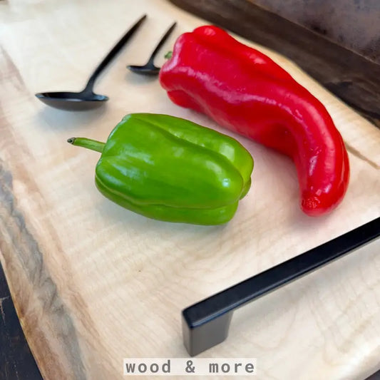 Frische rote und grüne Paprika auf einem Premium Schneidebrett Holz für die Küche