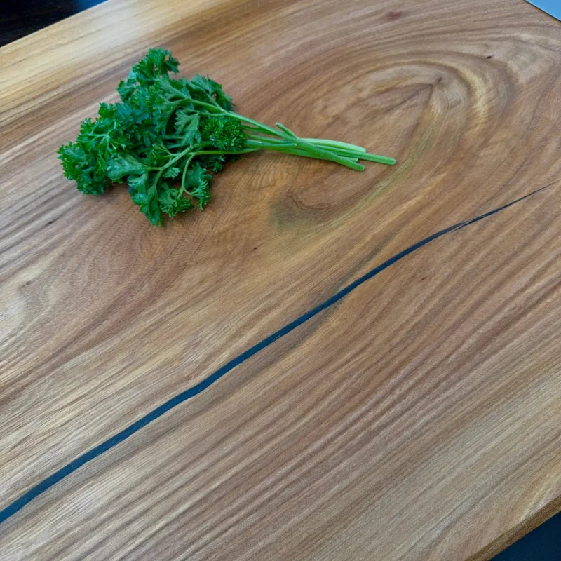 Frische Curly-Petersilie mit leuchtend grünen Blättern auf einem Massivholz Schneidebrett