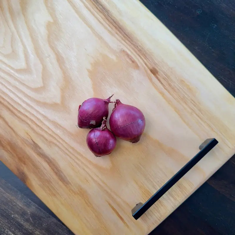Drei rote Zwiebeln auf einem eleganten UNIKAT Holz Schneidebrett aus Ulme