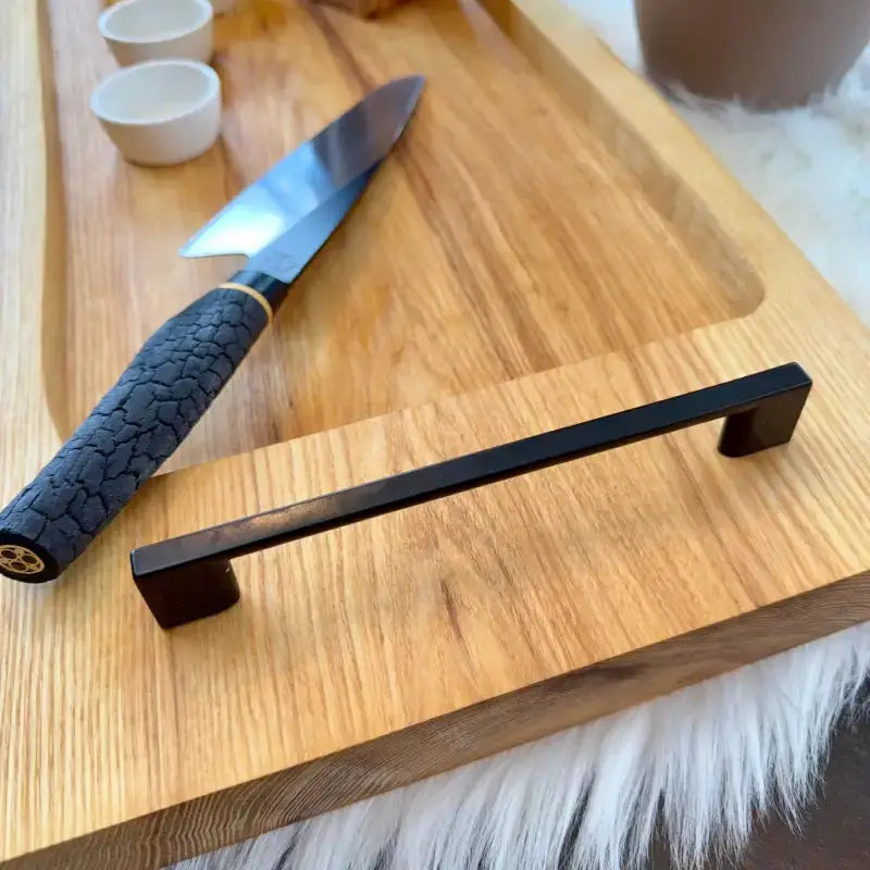 Chefsmesser mit texturiertem Griff auf Servierbrett aus Holz für BBQ und Grillen